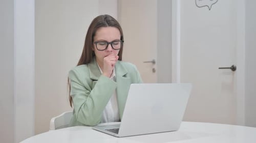 Woman Coughing While Working at Computer