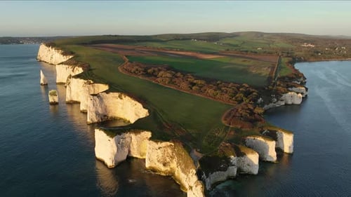 Sunrise at Old Harry Rocks with Swanage in the background, Dorset, aerial view.