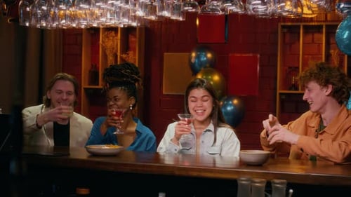 Four Friends Celebrating Birthday at Bar Counter, Clinking drinks
