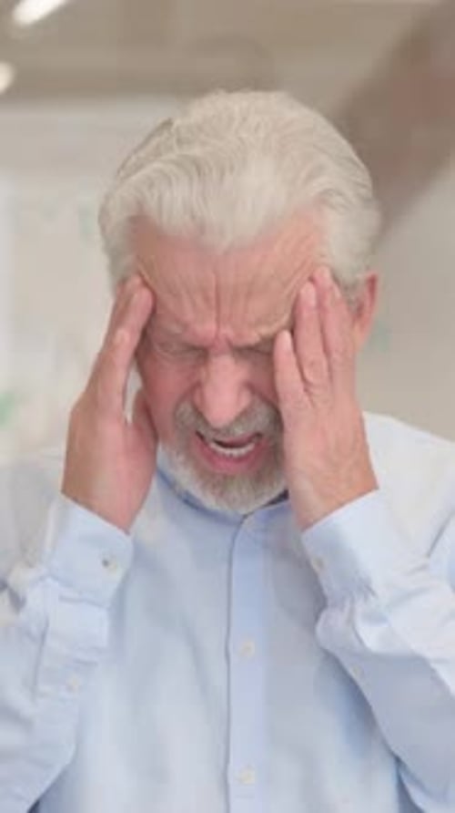 Senior Man With Headache Holding Temples In Pain