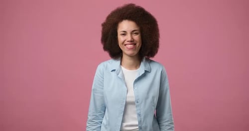 Smiling Woman Gesturing on Pink Background