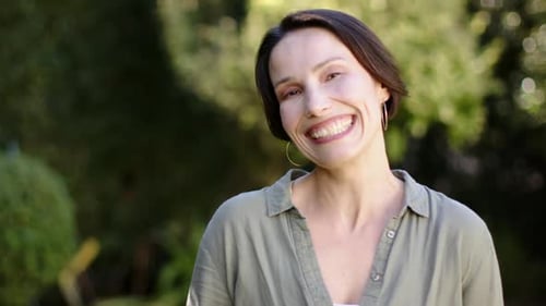 Smiling Woman Posing Outdoors in Sunlight