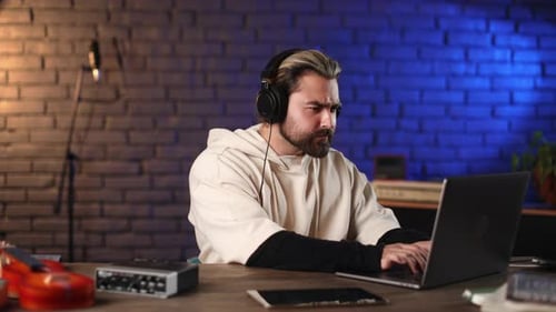 Man Working at Desk with Laptop and Tablet