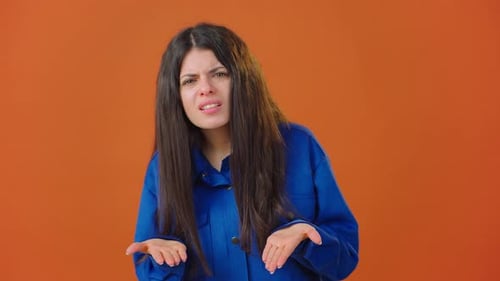 Brunette Woman Expressing Confusion on Orange Background