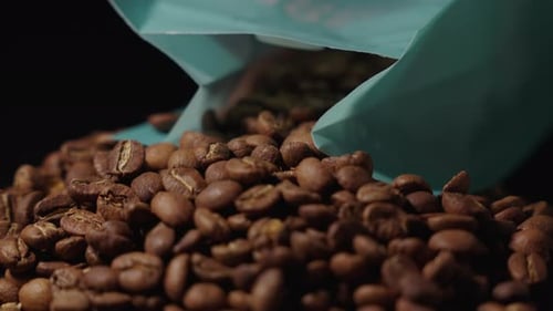 Aromatic Coffee Beans Cascading from a Blue Bag