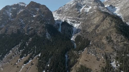 Vista aérea de las montañas del desfiladero de Barskoon con nieve y bosque de pinos en invierno