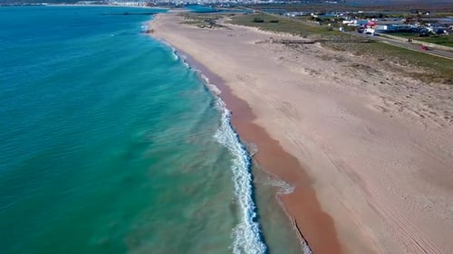 Aerial view of a empty beach with big waves in the south of Spain.
