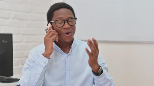 Young Adult Talking on Smartphone in Office Setting