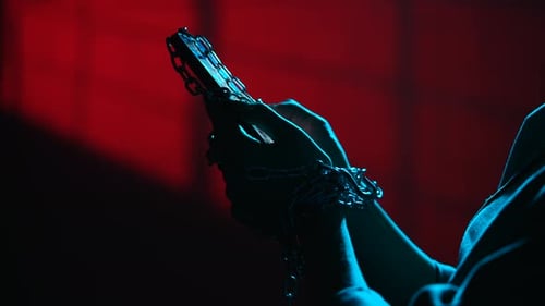 Hands Holding Smartphone Wrapped in Chains Symbolizing Digital Addiction