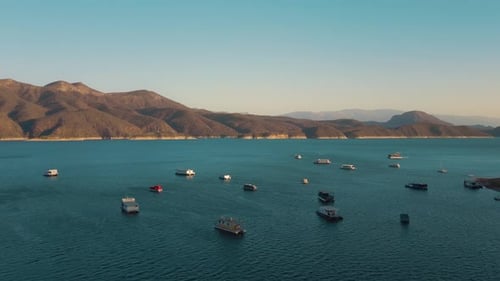 Aerial drone flying over a lake, water dam, with mountains at sunrise. Beautifull dreamy landscape v