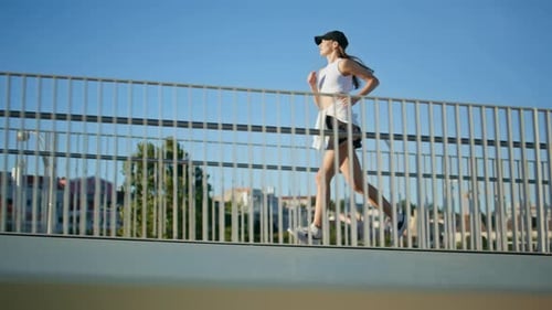 Athletic Woman Running Bridge in Front Clear Blue Sky Energetic Lady Jogging