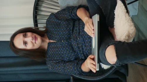 Woman Using Laptop at Home in Chair