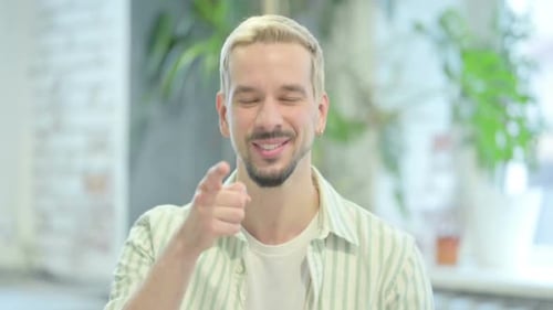 Blonde Man Smiling and Pointing