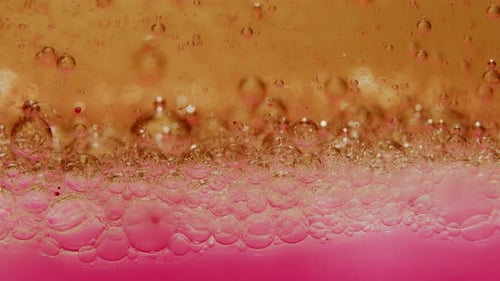 Oil swimming on Ink with lots of bubbles moving down (close up)