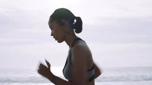 Woman, running and listening to music on beach sand in morning while outdoor for fitness