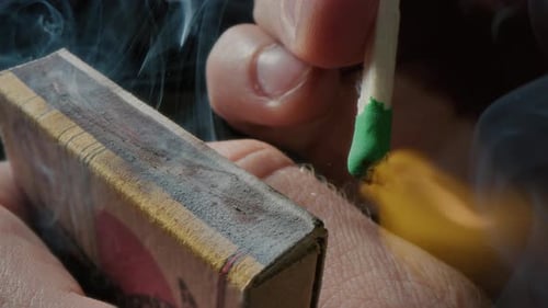 Hands Lights a Match with a Green Sulfur Head Slow Motion Strikes a Match on the Side of the Box