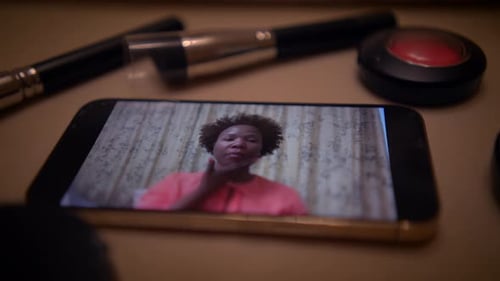Influenciadora de maquillaje femenina graba un vídeo de un producto de belleza en un teléfono inteligente