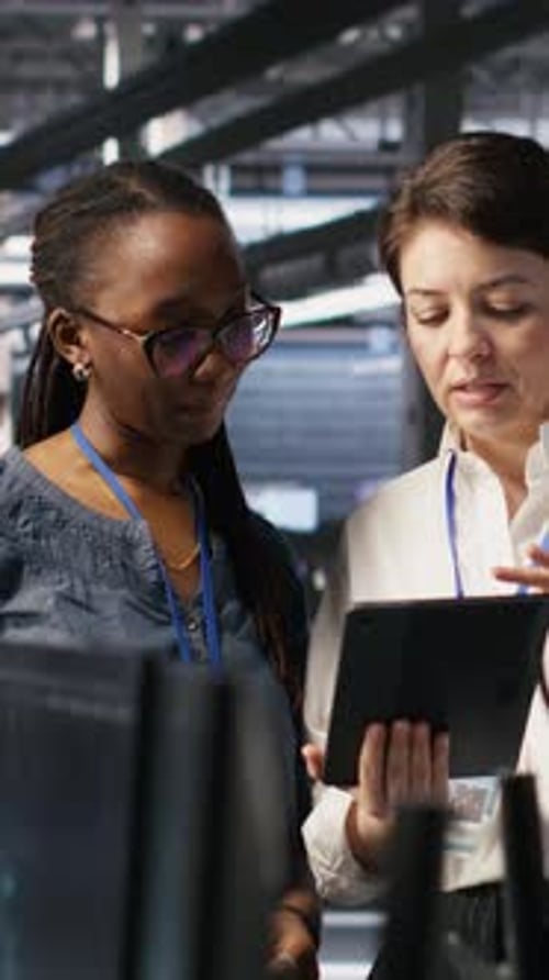 Vertical Video Data Center Teamworking Colleagues Performing Maintenance on Server Racks