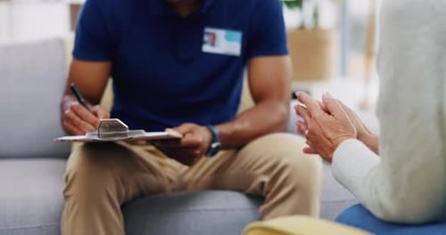 Man taking notes during a home visit consultation