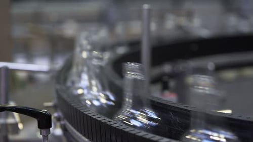 Bottles flowing seamlessly on a conveyor belt in a modern glass bottle factory