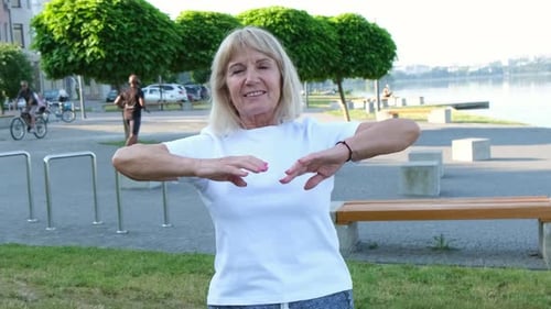 American Elderly Woman Stretches in the Park in the Morning Concept of Active Lifestyle
