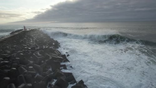 Waves Crashing on Rock Pier with Lighthouse