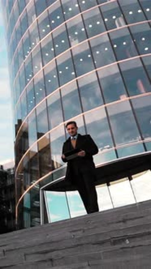 Vertical do homem de negócios usando o teclado digital ao ar livre