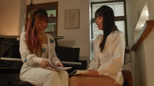 Smiling Women Reading Cards Near Piano Indoors