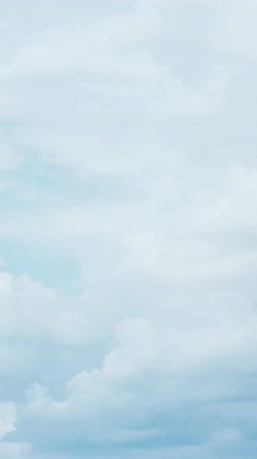 Timelapse of white fluffy clouds. Aerial view of light blue sky Vertical video