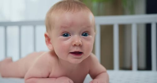 Adorable Baby Lying in Crib, Looking Around