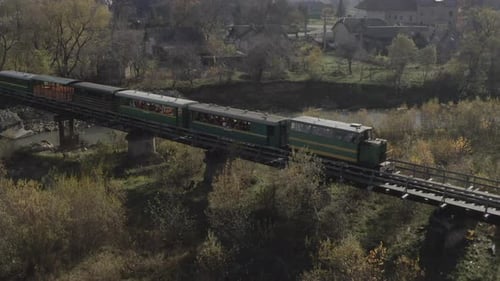 Aerial View of a Train Traveling Over a Railway Bridge Over a River