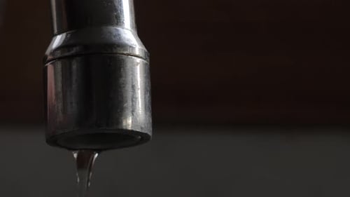 Leaking Metallic Faucet Dripping Water Close-Up