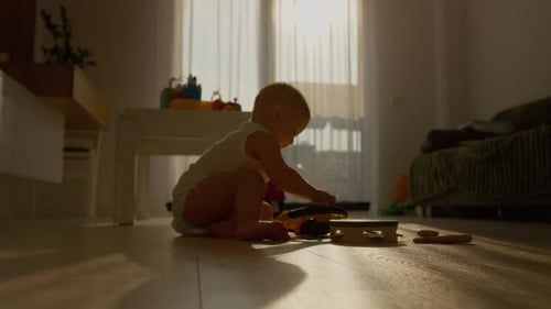 Infant Plays with Musical Toy at Home in Sunlight