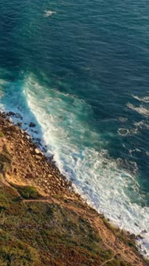Vue aérienne de haut en bas des vagues de l'océan qui se brisent sur les côtes des îles Rocheuses au Portugal