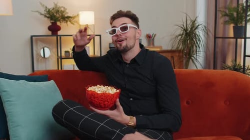 Young Adult Watching Movie with Popcorn at Home