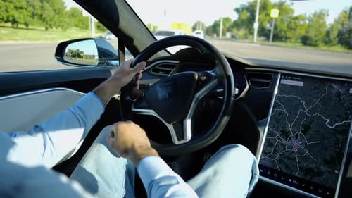 Hands of Businessman Holds Steering Wheel While Driving Electric Car at City Male Businessperson