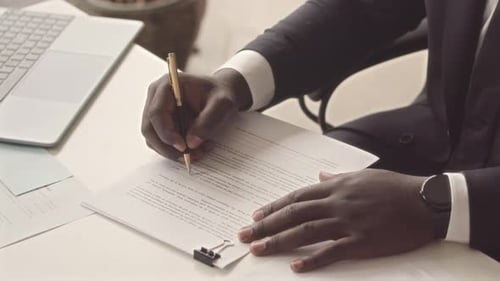 Man in Suit Signing Contract at Desk