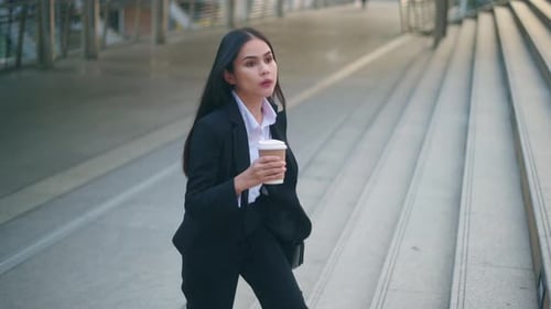 Business Woman Walking Up Stairs with Coffee