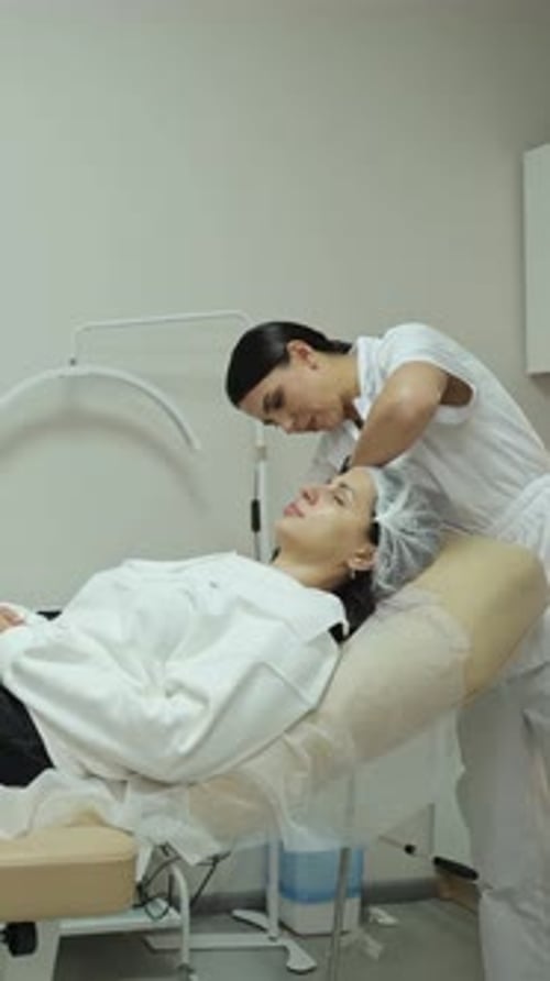 Aesthetician Giving Facial to Relaxed Woman in Clinic