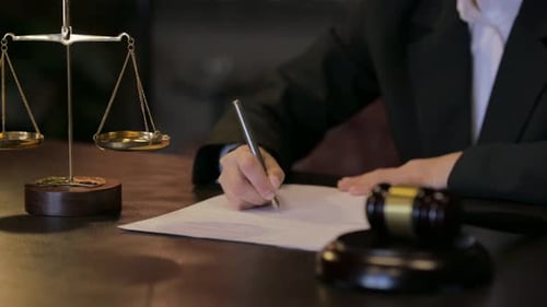 Close up of Female Judge Writing an Order in Courtroom