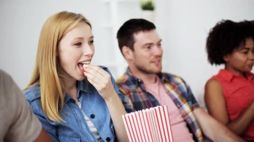 Friends enjoying watching movie together with popcorn