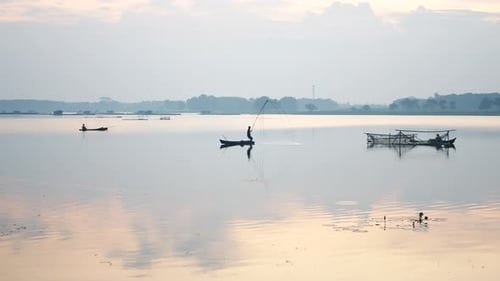 activities of Southeast Asian men riding traditional wooden boats to catch fish
