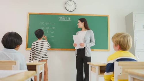 Group of student learn with teacher in classroom at elementary school.