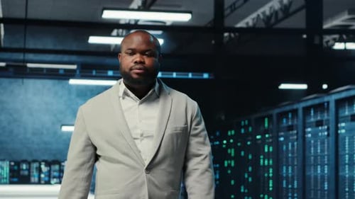 Employee Walking in Data Center with Blinking Lights on Rigs