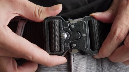 Gros plan d'un homme, attachez la boucle de ceinture en métal Cinto Tático Militar.