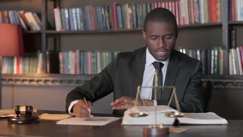 Man Reviews Documents at Office Desk