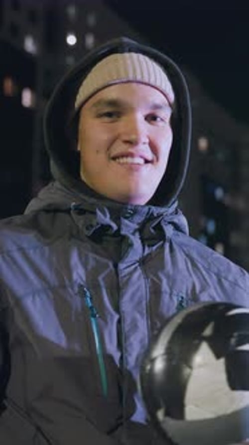 Young Adult Holding a Soccer Ball at Night