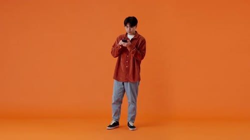 Asian Guy Checking Smartphone and Fists Pumping in Studio