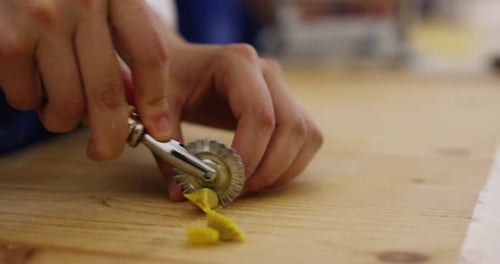 Professional expert chef mixes dry pasta with flour as an ancient Italian recipe procedure