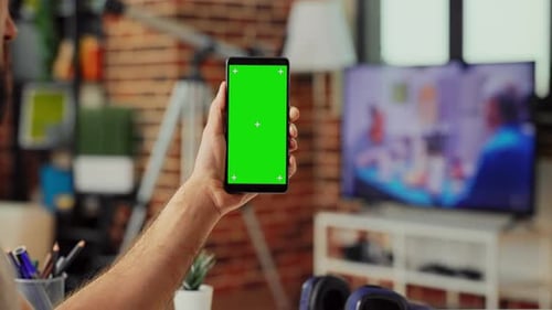 Male Freelancer Holding Smartphone with Green Screen Display